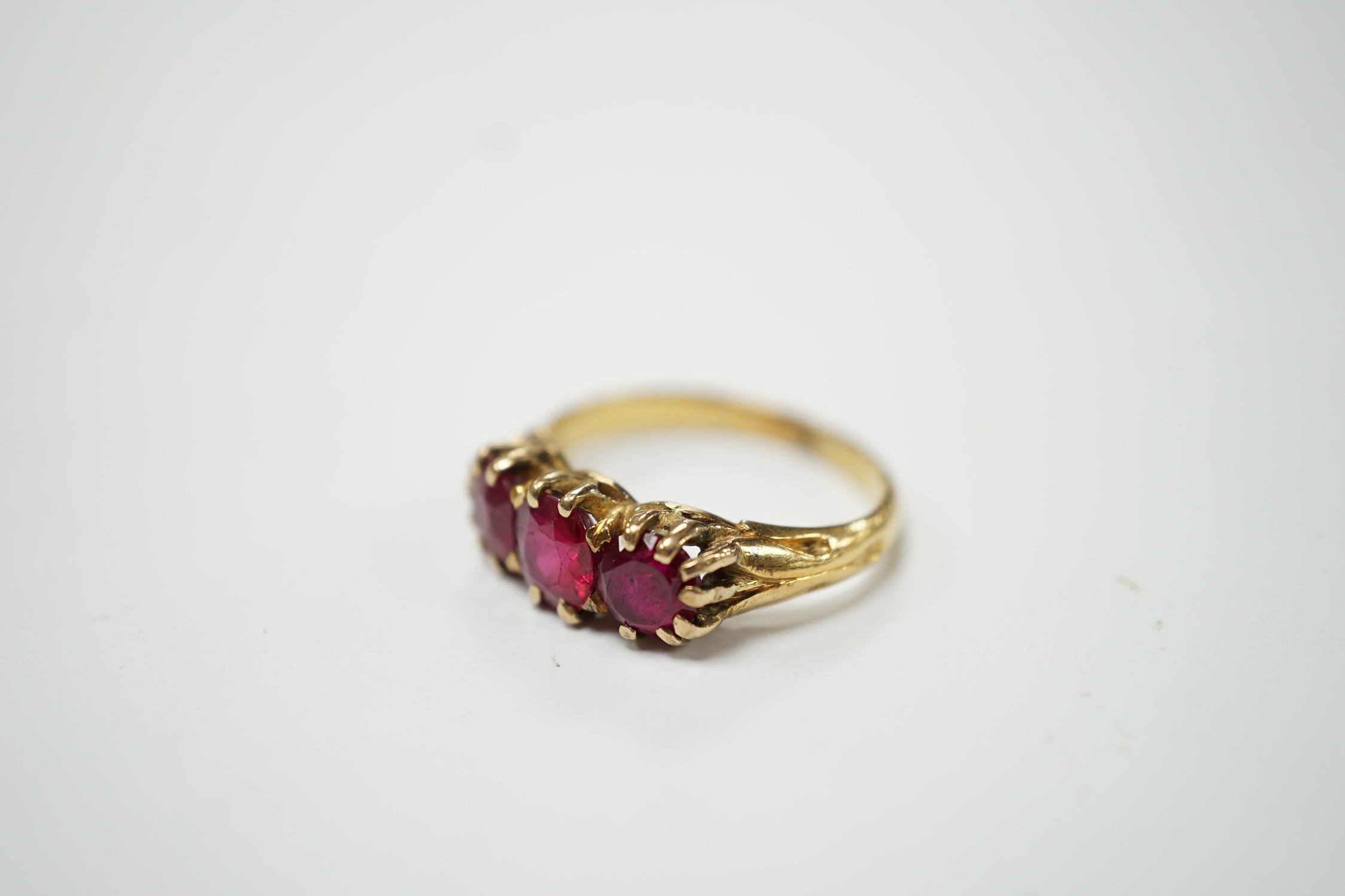 A yellow metal and three stone synthetic ruby set ring, size M, gross weight 4.8 grams. Fair condition.